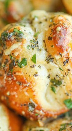 closeup of baked bread with herbs and cheese on the top, sitting on a plate