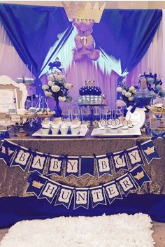 a baby shower themed dessert table with blue and gold decorations on it's sides