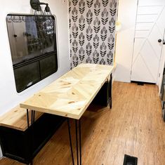 a table with hairpin legs in front of a wallpapered background and wooden floor