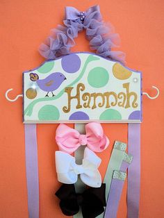 there is a sign that says happy hanging on the wall with some hair clips attached to it