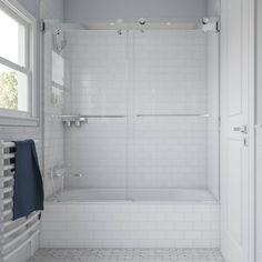 a white bathroom with a shower, toilet and bathtub next to two windows on the wall