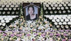 flowers are arranged in front of a portrait of a woman