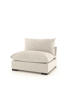 a white couch sitting on top of a white floor next to a pillow covered chair