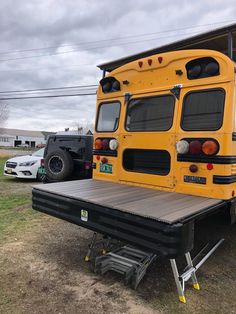 a yellow school bus parked in front of a building with a ramp attached to it