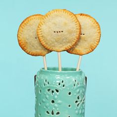 three crackers sitting on top of each other in a blue cup with toothpicks sticking out of it