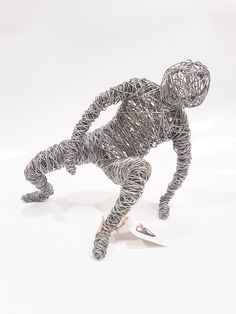 a wire sculpture of a man on a skateboard with one foot in the air