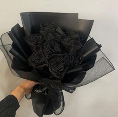 a person holding a bouquet of black roses