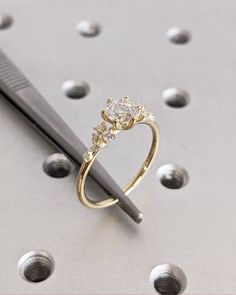 a diamond ring sitting on top of a table next to a pair of scissors and screwdrivers