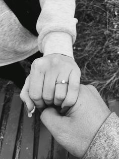 two people holding hands while sitting on a bench