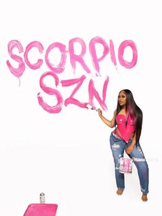 a woman is holding up the word scorpio san