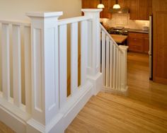 a kitchen with wooden floors and white railings