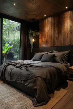 a large bed sitting next to a window in a room with wood paneled walls