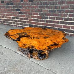 a piece of wood sitting on the ground next to a brick wall