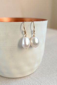 These gold earrings with real baroque pearls add a feminine and modern accent to the outfit of your choice. You can't go wrong with these earrings because they suit every woman.  The small ear hooks carry real freshwater pearls in a wonderful creamy white. The so-called baroque pearls impress with their asymmetrical, natural shape. No pearl is like the other and gives pieces of jewelery that certain something. D E T A I L S - earrings: 14k Gold Fill - pearls: real baroque pearls, 8-9 mm - custom Elegant Everyday Pearl White Pearl Earrings, Elegant Everyday Pearl White Earrings, Elegant White Pearl Charm Earrings, White Drop Pearl Earrings For Everyday Elegance, Everyday White Pearl Pendant Earrings, Elegant Everyday Pear-shaped Earrings, Classic Baroque Pearl Drop Earrings, Classic White Pearl Earrings For Everyday Elegance, Classic White Pearl Earrings In 14k Gold