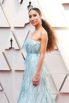 a woman in a blue dress on the red carpet at an oscars event with long hair