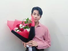 a young man holding a bouquet of flowers