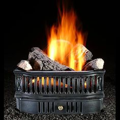 a close up of a fire in a fireplace with rocks and logs on the ground