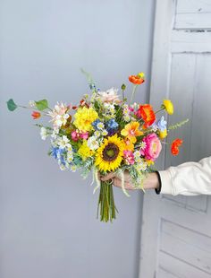 a person holding a bouquet of flowers in their hand