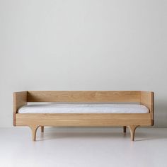 a bed that is made out of wood and has no sheets on the bottom half