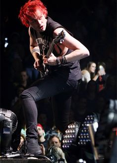 a man with red hair playing an electric guitar