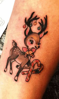 a tattoo with a deer and candy cane on it