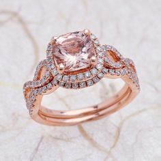 an engagement ring with a pink diamond surrounded by white and rose gold pave diamonds