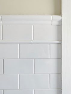 a bathroom with white tile on the wall