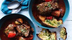 two blue bowls filled with stew and bread