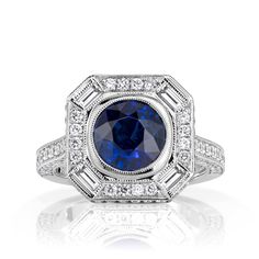 Behold our enchanting vintage-inspired 3.32ct cushion cut blue sapphire engagement ring, a true symbol of classic elegance set in timeless platinum. The centerpiece is a GIA-certified 2.32ct, 7.40x7.38mm cushion cut stunning blue sapphire which radiates beauty and classic style. The halo design features a dazzling array of round brilliant and baguette diamonds, accentuating the stunning center stone. The halo and shank are adorned with a total of 1ct top-quality E-F color and VS1-VS2 clarity dia Classic Blue Halo Ring, Classic Blue Radiant Cut Sapphire Ring, Timeless Blue Cushion Cut Ring, Classic Blue Sapphire Halo Ring, Classic Blue Asscher Cut Sapphire Ring, Classic Asscher Cut Lab-created Sapphire Ring, Blue Sapphire Ring With Cushion Diamond Cut, Blue Sapphire Ring With Diamond Cushion Cut, Gia Certified Square Cut Blue Sapphire Ring