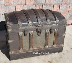 an old trunk sitting in front of a brick wall