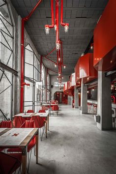 the interior of a restaurant with red chairs and lights hanging from the ceiling over tables