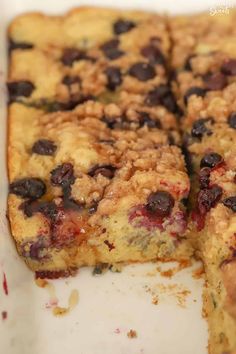 a close up of a cake with blueberries on it and crumbs around the edges