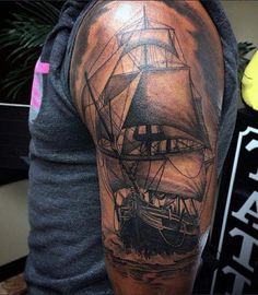 a man with a ship tattoo on his arm