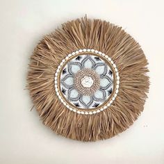 a decorative wall hanging made out of straw with a circular design on the center and sides