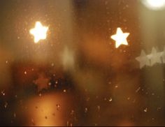 stars are seen through the rain on a window