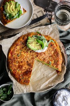 a piece of quiche with avocado and sour cream on top