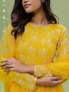 A three-piece sunshine embroidered sharara set from the Redpine Designs collection. This gorgeous sunshine yellow printed flared sharara pant is paired with a floral embroidered kurta. The yellow color with moti, cutdana, sequins work enhances the graceful georgette sharara set. The yellow sharara has beautiful digital floral print with heavy flare style. The embroidered kurta has a jewel neckline with digital floral print all over. This beautiful sharara set includes a yellow net dupatta with e Designer Yellow Chikankari Embroidery Palazzo Set, Designer Yellow Palazzo Set With Chikankari Embroidery, Traditional Yellow Palazzo Set With Gota Work, Yellow Chikankari Embroidered Palazzo Set, Yellow Palazzo Set With Gota Work And Straight Kurta, Festive Yellow Chikankari Palazzo Set, Yellow Palazzo Set With Straight Kurta And Gota Work, Yellow Palazzo Set For Diwali, Yellow Chikankari Embroidery Palazzo Set For Eid