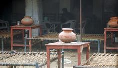 several vases sitting on top of tables in front of an open air room with chairs