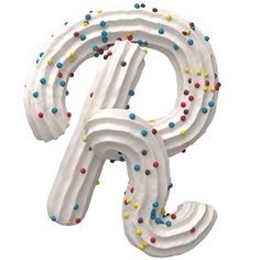 the letter p is decorated with white frosting and multicolored sprinkles