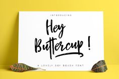 a sign that says hey buttercup on it next to two small leafy plants