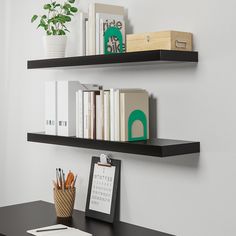 two black floating shelves with books and office supplies