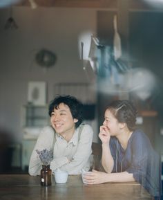 two people are sitting at a table and smiling