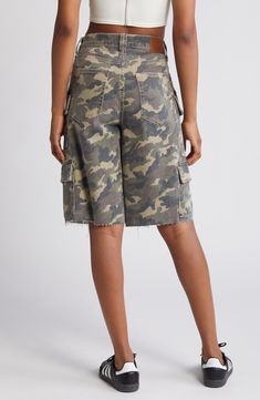 Channel laid-back skater style with these baggy denim shorts featuring camo print, a plethora of cargo pockets and raw hems for a lived-in look. 12" inseam; 12" rise Zip fly with button closure Five-pocket style; cargo flap-patch pockets 94% cotton, 5% polyester, 1% spandex Machine wash, tumble dry Imported Camouflage Relaxed Fit Utility Bottoms, High Rise Cotton Cargo Shorts With Side Pockets, Streetwear Short Length Cargo Jeans, Short Length Cargo Jeans For Streetwear, Utility Jean Shorts With Cargo Pockets For Streetwear, High Rise Camouflage Bottoms With Pockets, Casual High Rise Cargo Shorts With Pockets, Utility Jean Shorts For Streetwear, Trendy Camouflage Shorts With Pockets