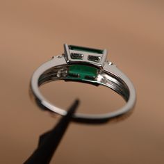 It is a lab emerald ring. The main stone is 6mm*8mm emerald cut, weight about 1.50 carats. The basic metal is sterling silver and plated with rhodium. To change the metal to a solid gold (white/rose) or platinum is also available, please ask for a quotation if you want. You can also go to my shop Home for more elegant rings: https://www.etsy.com/shop/godjewelry?ref=hdr_shop_menu More emerald rings: https://www.etsy.com/shop/godjewelry?ref=seller-platform-mcnav§ion_id=20709240 Customization is al Emerald Radiant Cut Promise Ring, Emerald Cut Emerald Ring With Halo Setting, Silver Emerald Cut Ring For May Birthstone, Green Emerald Cut Ring With Halo Setting, Baguette Cut Emerald Promise Ring With Accent Stones, May Birthstone Ring With Emerald Cut And Halo Setting, Sterling Silver Emerald Cut Ring For May Birthstone, Sterling Silver Emerald-cut Ring With Center Stone, Green Emerald Cut Birthstone Ring With Halo Setting