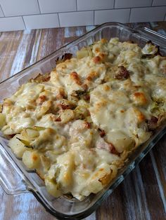 a casserole dish with meat and cheese in it sitting on a wooden table