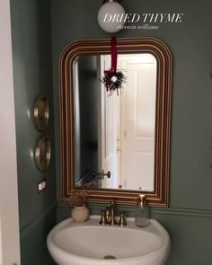 a bathroom sink sitting under a mirror next to a wall mounted faucet in front of a doorway