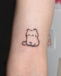 a small dog tattoo on the left inner arm and wrist, which is drawn in black ink