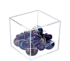 a clear box filled with lots of purple and black balls on top of each other