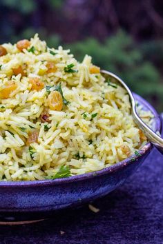 a bowl filled with rice and vegetables on top of a purple cloth covered tablecloth