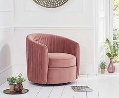 a pink chair sitting on top of a white floor next to a clock and potted plants